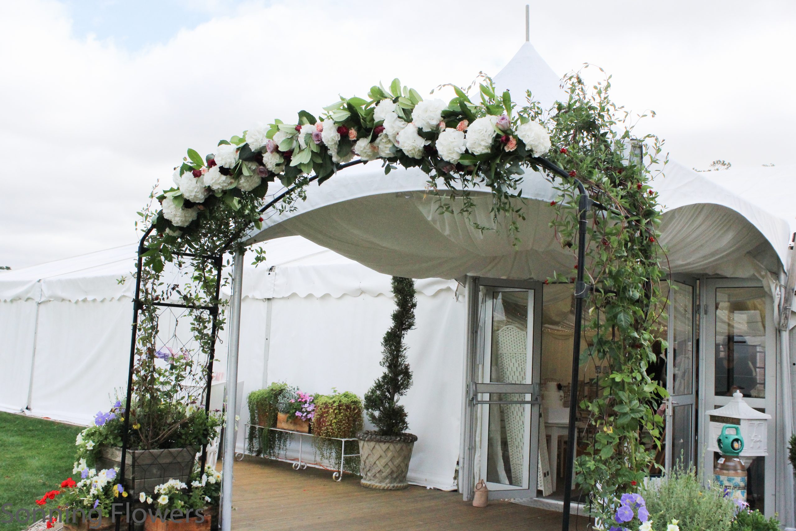 A beautiful flower arch with drapes at the marquee entrance